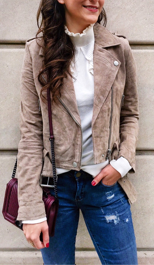 White turtle neck shirt sleeves and brown leather pea coat.