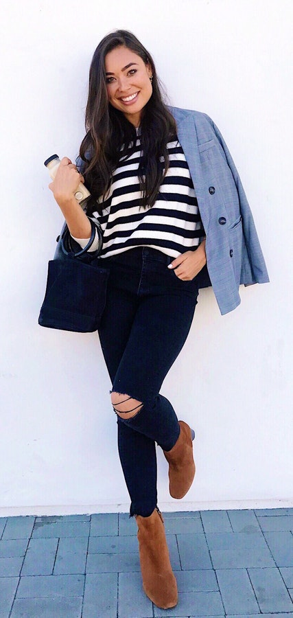 Women's black-and-white stripe shirt, blue blazer, and distressed black pants.