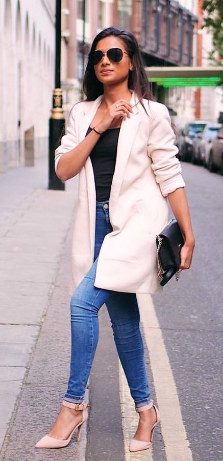 Women's white coat and blue denim jeans.